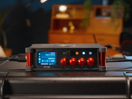Behringer FLOW 4V 32-bit float field recorder on a hard case, featuring colour display, red gain knobs, MIDAS mic preamps, and compact portable design for audio-for-video and field recording workflows